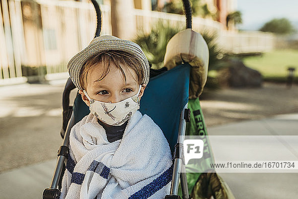 Close up portrait of young boy with mask on outside on vacation
