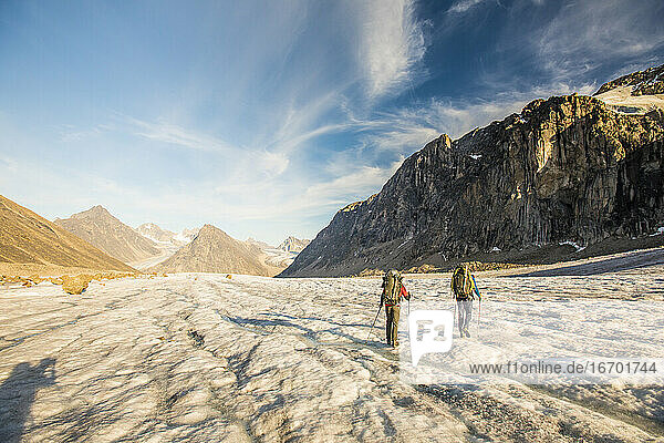 Rückansicht von Rucksacktouristen beim Überqueren des Gletschers