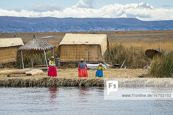 Frauen in traditioneller Kleidung warten auf Touristen  die zu den Uros-Inseln kommen  Titicacasee  Peru