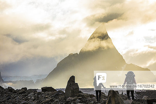 Rückansicht von Rucksacktouristen  die sich dem dramatischen Berg Mt. Loki nähern