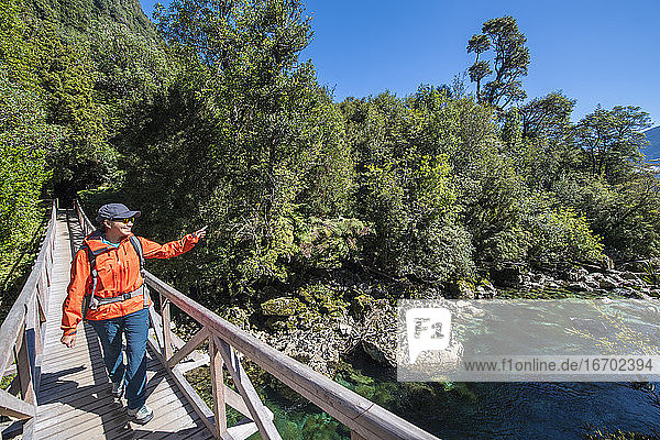 Frau überquert Holzbrücke bei Caleta Gonzalo in Chile