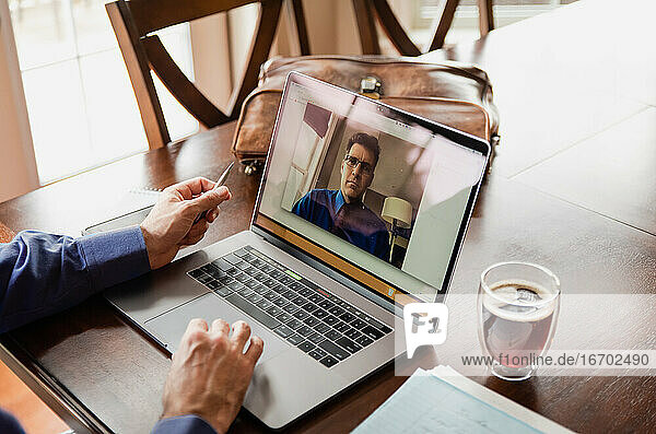 Man in virtual business meeting on computer while working from home.