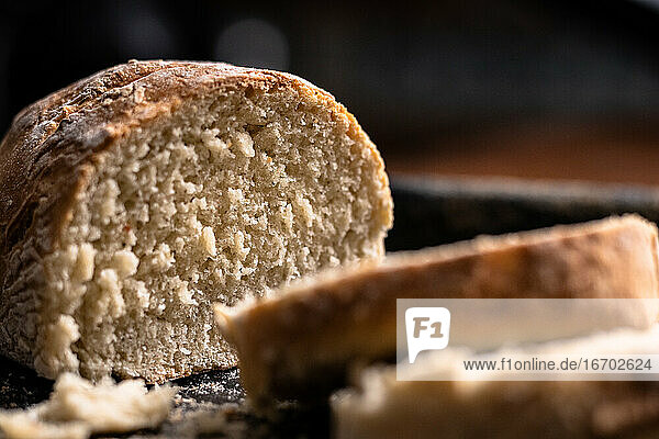 Gebackenes hausgemachtes Brot auf schwarzem und hölzernem Hintergrund  Bäckerei Einstellung.