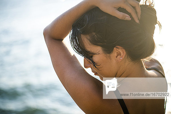 Junge Latina Frau entspannt am Meer zur goldenen Stunde im Sommer