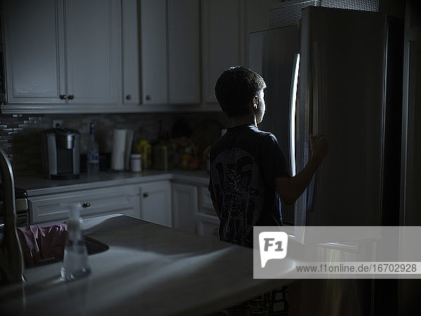 Ein 12-jähriger Junge sucht nach einem nächtlichen Snack im Kühlschrank