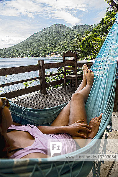 Frau entspannt in Hängematte auf der tropischen Insel Ilha Grande