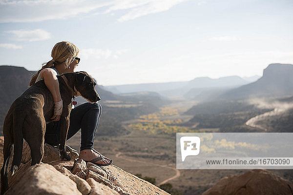 Eine Frau und ihr Hund genießen die Aussicht auf die Wüste  Utah