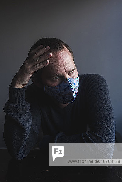 Porträt eines weißen Mannes  der sich vor einer Pandemie fürchtet und einen Mundschutz trägt