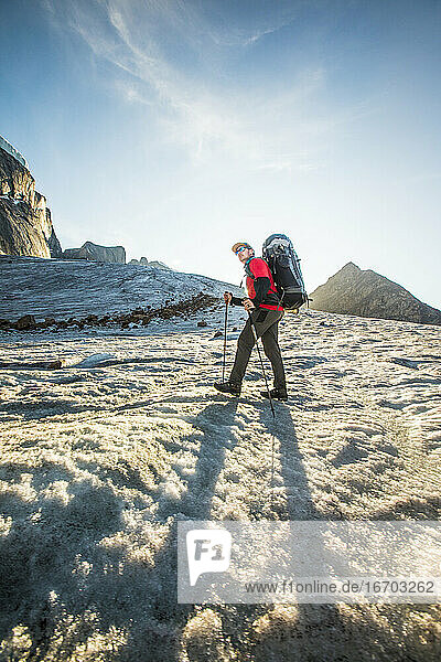 Tiefblick auf einen Rucksacktouristen beim Überqueren eines Gletschers.