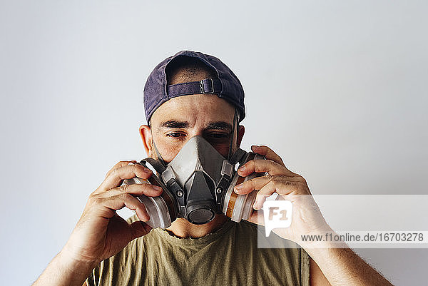 Portrait of airbrush painter putting on his protective mask.
