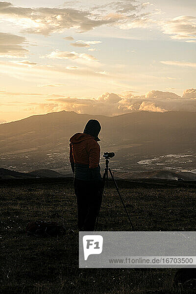 Fotograf fotografiert in den Bergen mit gelbem Sonnenuntergang