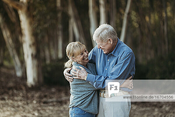 Porträt eines älteren erwachsenen Paares  das sich im Wald umarmt
