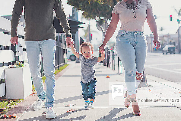 Family of three walking in Downtown  baby boy walking with parents