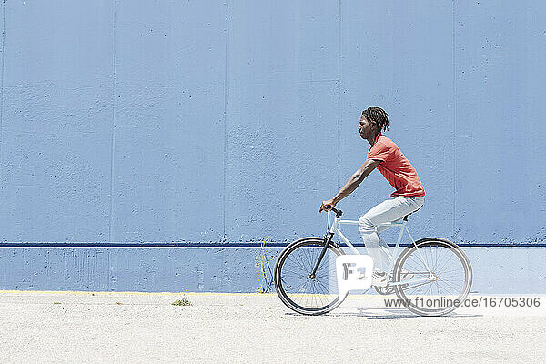 Mann fährt Fahrrad auf einer Böschung