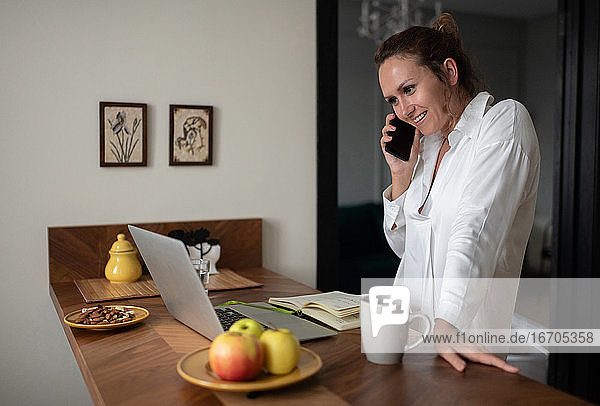 Fröhliche Geschäftsfrau nimmt Telefonanrufe entgegen