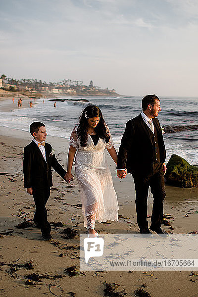 Newlyweds & Nine Year Old Son Walking Along Beach in San Diego
