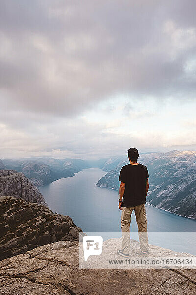 Mann steht am Rande einer Klippe am Preikestolen  Norwegen