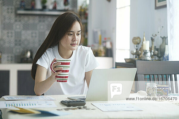 Attraktive junge Asiatin  die zu Hause arbeitet.
