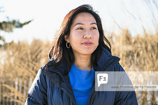 Closeup Portrait of Asian Woman outdoors smiling at the beach