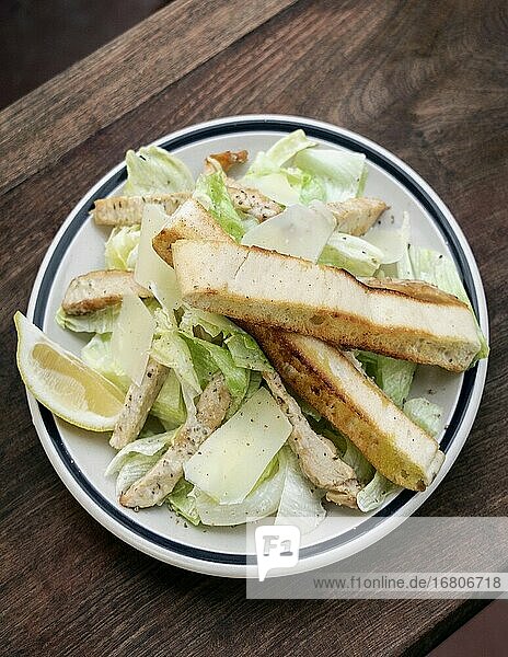 Einfacher gesunder orgaanischer Hähnchen-Caesar-Salat auf Holztisch.