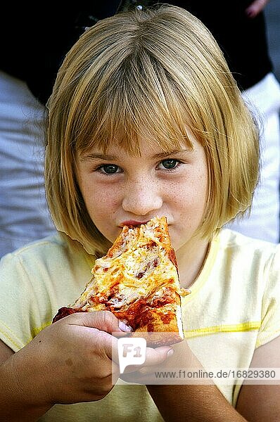 Junges Mädchen isst Pizza bei einem Picknick.