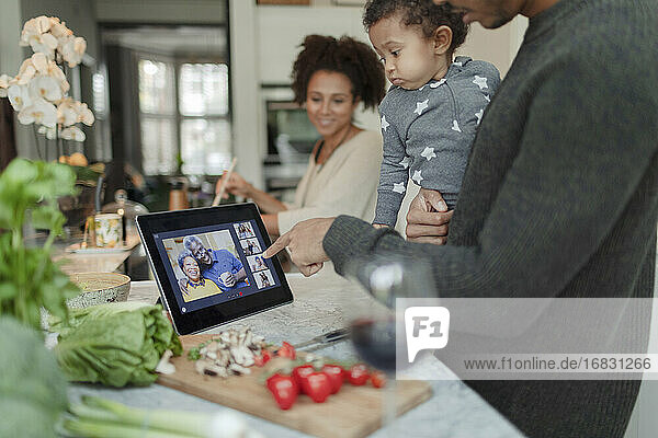 Familie Video-Chat am digitalen Tablet und Kochen Abendessen in der Küche