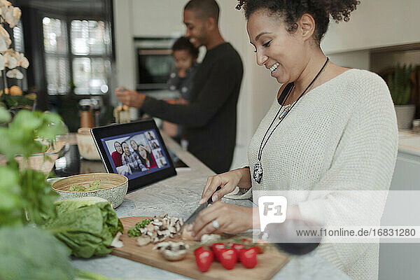 Glückliche Frau Kochen und Video-Chat am digitalen Tablet in der Küche
