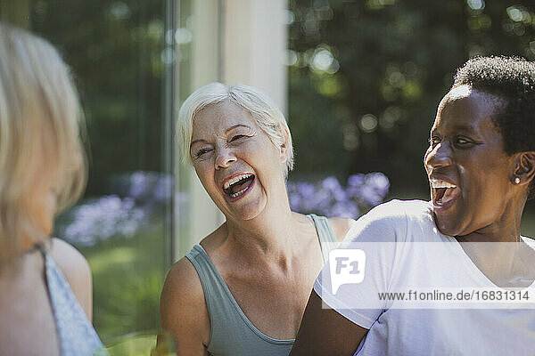 Glückliche ältere Frauen Freunde lachen auf Sommerterrasse