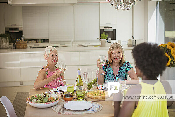 Senior Frauen Freunde genießen Weißwein mit Mittagessen am Esstisch