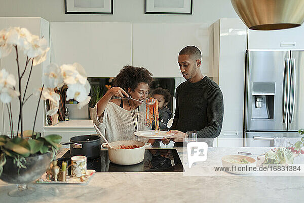 Paar mit Baby Tochter Kochen Spaghetti in der Küche