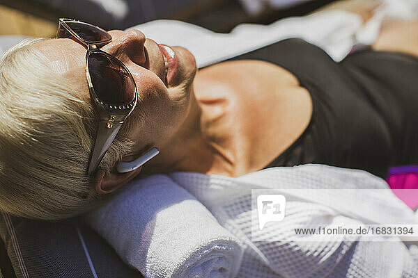 Close up happy senior woman in sunglasses sunbathing