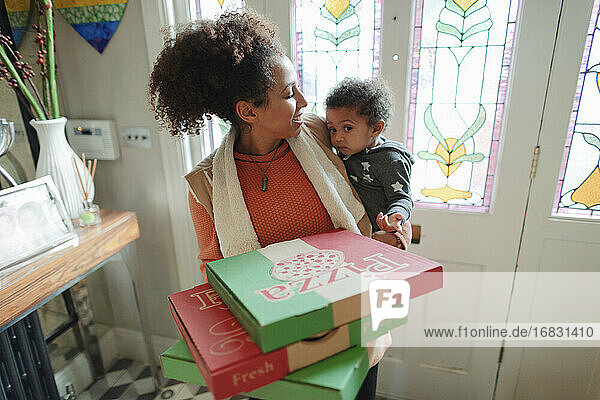 Mutter mit Baby Tochter erhalten Pizza Lieferung an der Haustür