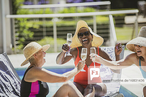 Glückliche ältere Frauen Freunde trinken Champagner bei sonnigen Sommer poolside
