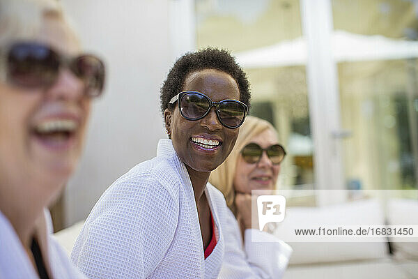 Portrait happy senior women friends in spa bathrobes and sunglasses