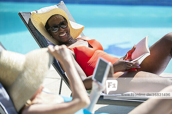 Glückliche ältere Frauen Freunde entspannen und Sonnenbaden am sonnigen Pool
