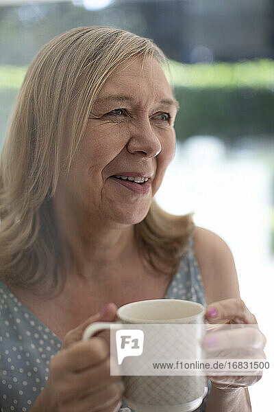 Glückliche ältere Frau trinkt Tee