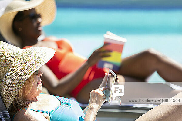 Senior Frau mit Smartphone und Sonnenbaden am Sommer-Pool