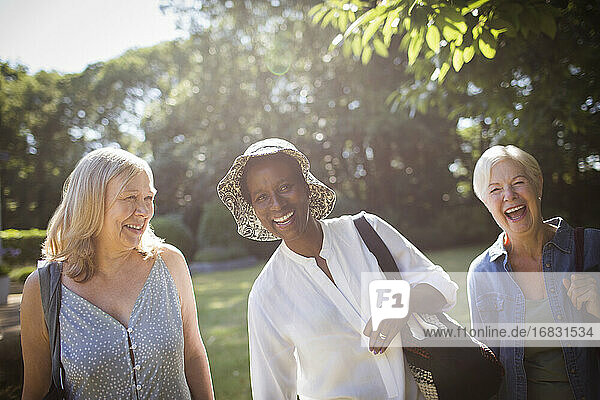 Portrait happy senior women friends in sunny summer garden