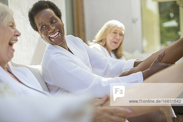 Playful Senior Frauen Freunde in Spa-Bademäntel auf Hotel-Terrasse