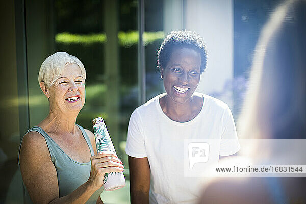 Glückliche ältere Frauen Freunde lachend auf sonnigen Sommer-Terrasse