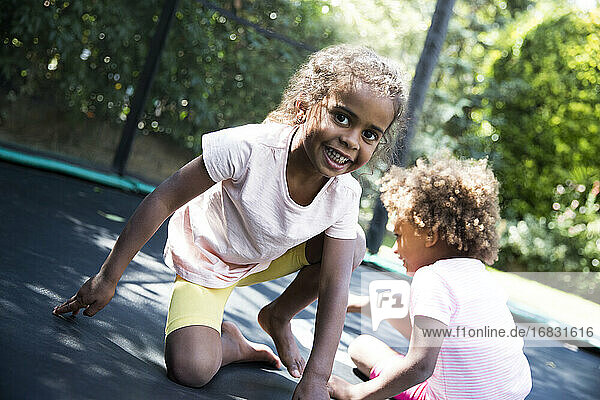 Porträt sorglos Schwestern spielen auf Hinterhof Trampolin