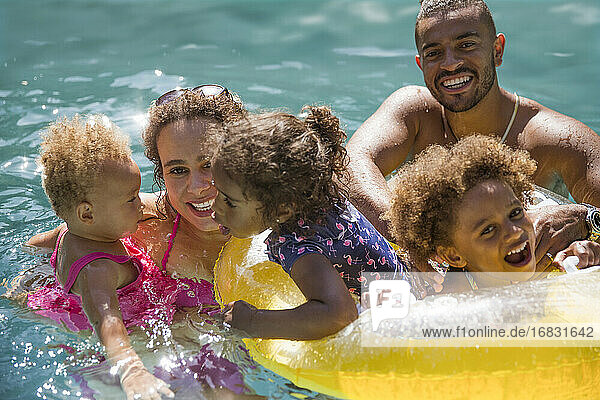 Porträt glückliche Familie spielen in sonnigen Sommer Schwimmbad
