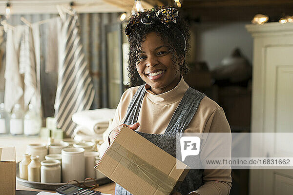 Porträt glückliche weibliche Ladenbesitzerin mit Paket