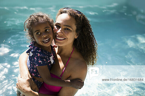 Porträt glücklich Mutter und Tochter in sonnigen Sommer Schwimmbad