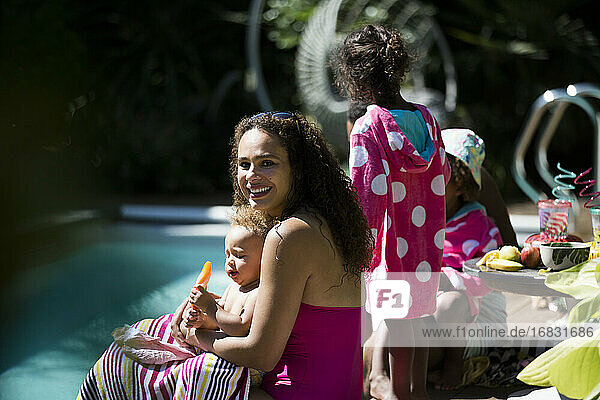 Porträt glückliche Mutter und Tochter genießen aromatisiertes Eis am Pool