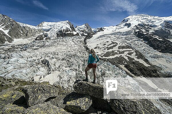 La Jonction  hiker in front of glacier tongue  Glacier des Bossons meets Glacier de Taconnaz  left summit Mont Maudit  right Mont Blanc  Chamonix  Haute-Savoie  France  Europe