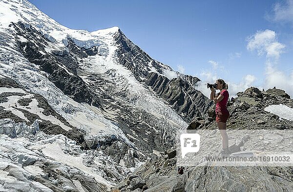 La Jonction  Wanderin fotografiert Gletscherzunge  Glacier des Bossons trifft auf Glacier de Taconnaz  links Gipfel Mont Maudit  rechts Mont Blanc  Chamonix  Haute-Savoie  Frankreich  Europa