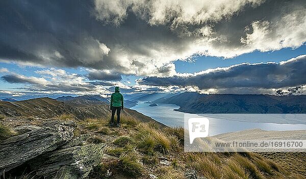 Wanderin blickt in die Ferne  Blick auf Lake Wanaka im ABendlicht  See und Berglandschaft  Ausblick vom Isthmus Peak  Wanaka  Otago  Südinsel  Neuseeland  Ozeanien