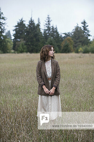 Porträt eines siebzehnjährigen Mädchens mit Tweed-Blazer  stehend in einem Feld mit hohen Gräsern  Discovery Park  Seattle  Washington