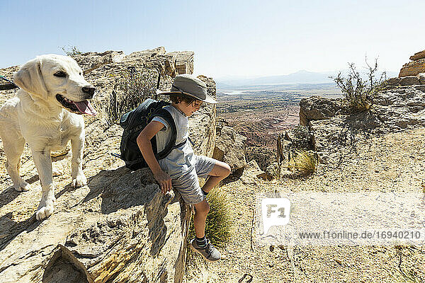 young boy hiking with his dog on Chimney Rock trail  through a protected canyon landscape